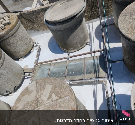 מיכלים עגולים על גג עם צינורות ואיטום לבן